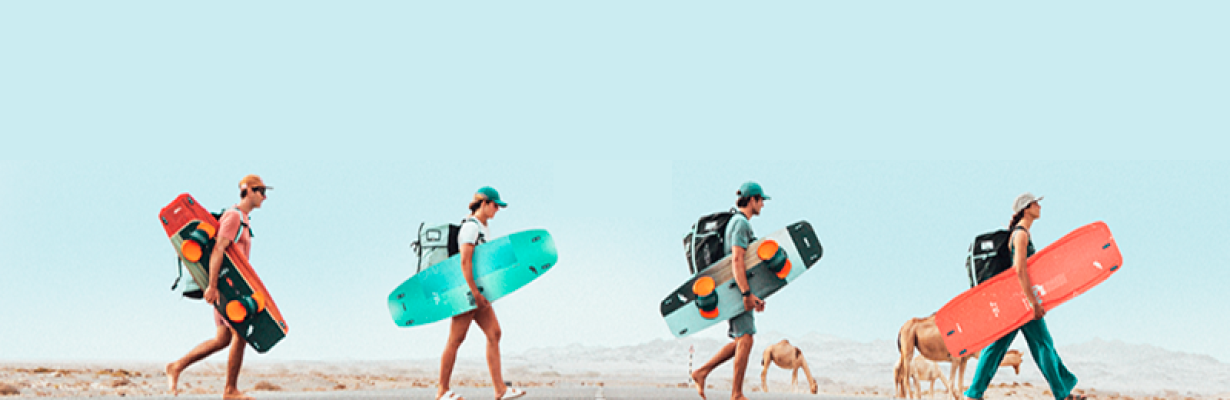 Dos personas transportando tablas de kitesurf en direccion a kite cordoba
